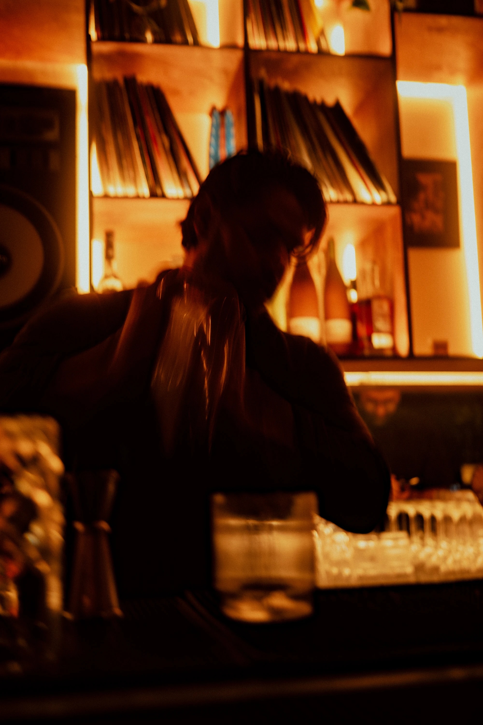A bartender working beneath the record shelves at The Felix